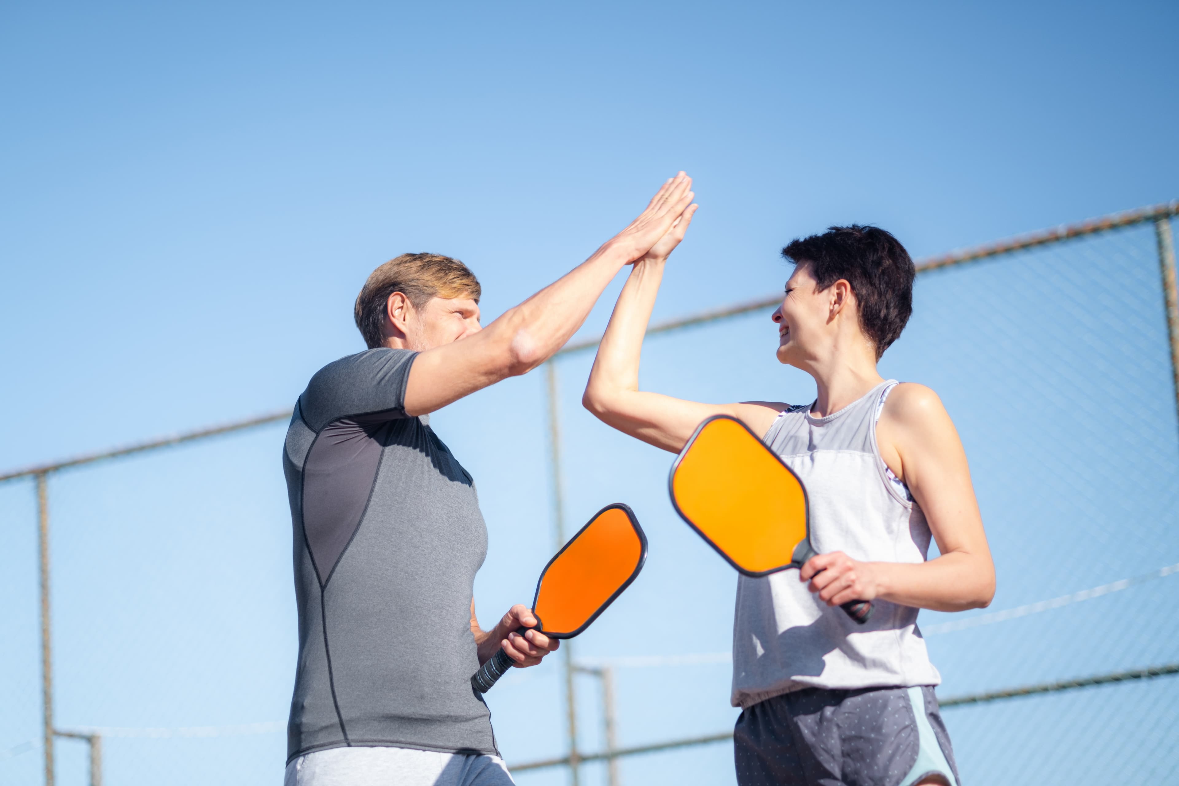 High five of two pickleball players
